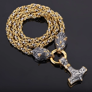 Detail of Viking Thor hammer pendant with golden wolf head accents on a woven chain