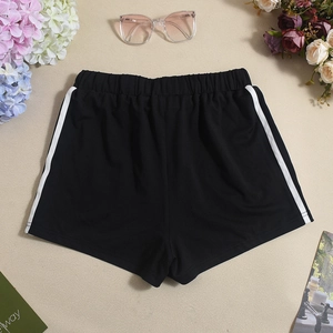 Flachbild von schwarzen Sportshorts mit weißen Seitenstreifen und elastischem Bund neben Blumen
