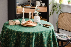 Detail of Christmas green tablecloth with gold snowflake patterns on thick linen fabric