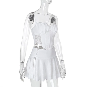 Detail of white corset top and mini skirt set with lace panels and satin fabric texture