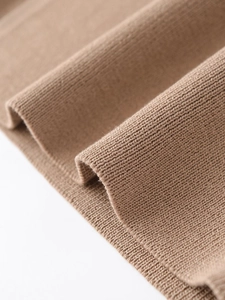 Macro shot of high-quality camel ribbed knit fabric detail showing texture and stitching