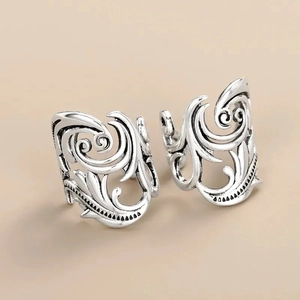 Detailed macro shot of vintage silver rings featuring hollowed-out leaf vine patterns