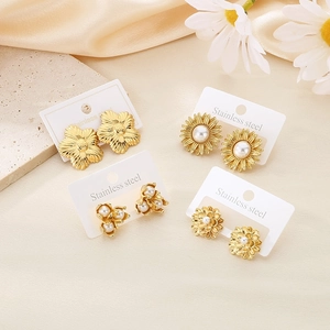 Vintage gold stainless steel floral earring set with shells and pearls on silk background