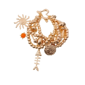 Vintage gold layered bracelet with sun, fish bone and shell charms on white background