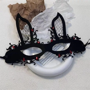 Detail of black rabbit ear masquerade mask with mesh inserts and red faux gems