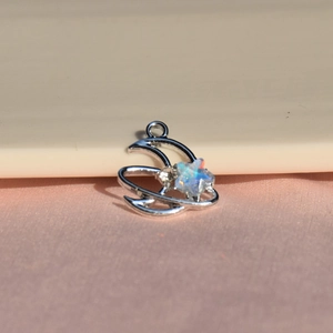 Vue macro d'un pendentif lune en argent avec une étoile d'opale sur soie rose