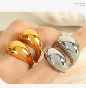 Macro detail of glossy 18K gold and silver chunky sphere rings on model fingers