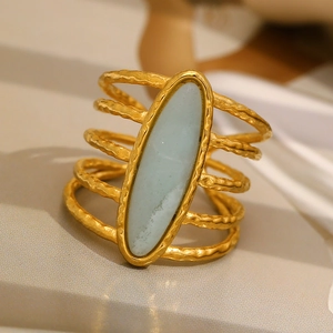 Macro detail of 18K gold-plated ring with blue oval stone and hammered texture metal