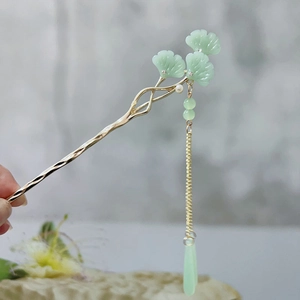 Macro shot of green ginkgo leaf hair pin with delicate pearl tassels in gold finish