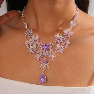 Close-up of vintage flower necklace with purple drop crystals and silver floral design