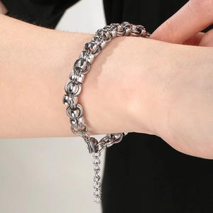 Detail of silver interlocking ring chain bracelet with adjustable link on model wrist