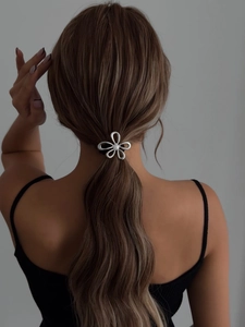 Detail of silver hollow flower hair ring with white pearl on a model ponytail