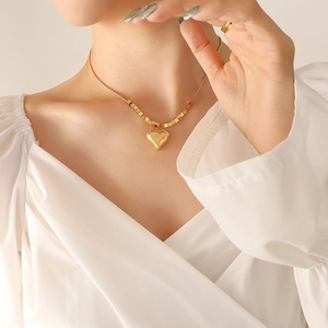 Minimalist gold heart pendant necklace with square bead snake chain on model