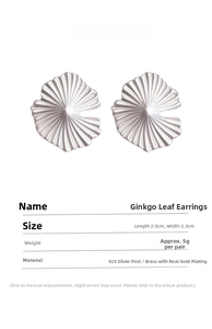 Detail view of silver ginkgo leaf earrings with 925 silver needles and brass texture