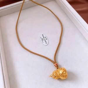 Macro detail of 24k gold-plated hollow gourd pendant with intricate floral engraving
