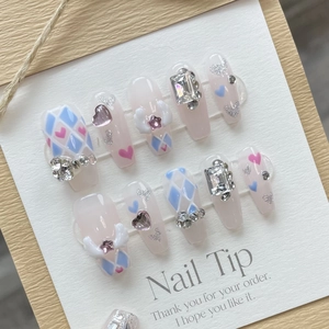 Handmade nail tips with 3D angel wings and rhinestones in soft white and pink colors