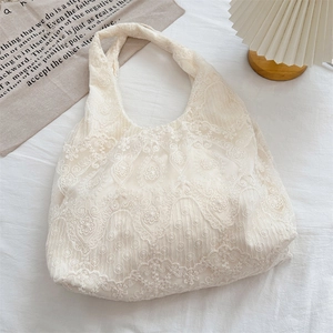 Close-up of cream white floral lace texture and embroidery on this elegant tote bag