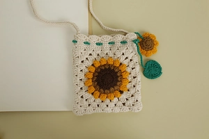 Detailed view of hand-woven crochet crossbody bag with 3D sunflower pattern and strap