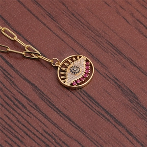 Close-up of gold paperclip chain and evil eye pendant with micro-pave multicolored zircons