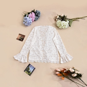 Detail shot of white floral lace fabric with elegant bell sleeves and hollow out texture