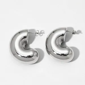 Detailed close-up of chunky silver hollow C-shaped earrings with mirror-polished finish