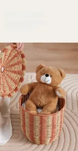 Detail of red and yellow striped circus rattan basket storing large plush bear toys