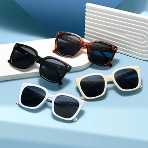 Square oversized sunglasses in white, black, and beige colors on geometric props