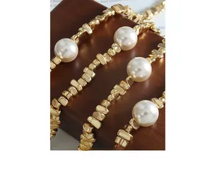 Primer plano de un elegante collar vintage con perlas blancas y cuentas doradas geométricas