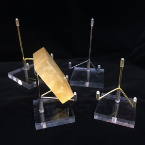 Close-up of gold and silver metal claw stands on clear acrylic bases for crystal display