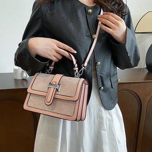 Pink leather handbag detail featuring embossed patterns and silver metal buckle closure
