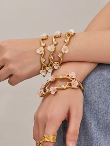 Macro detail of gold plated floral C-shape open bangle with 5A zircon and petal inlay