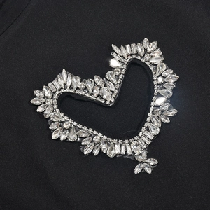 Détails de strass argentés en forme de cœur sur tissu noir pour un style street chic