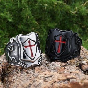 Macro shot of medieval shield cross rings on rustic bark with red enamel detail