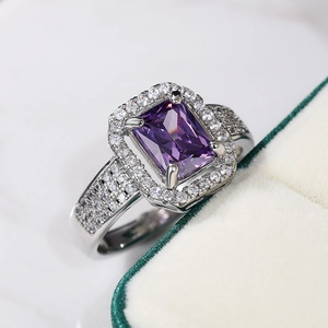 Macro shot of double-layer silver ring with square purple zircon and claw setting detail