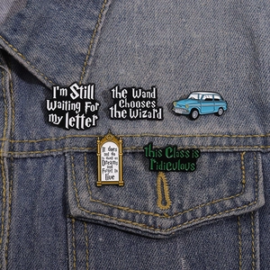 Set of five wizard themed enamel pins with movie quotes on a blue denim jacket pocket