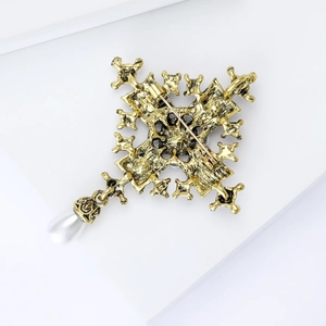 Detailed back view of golden baroque cross brooch with pearl showing secure pin fastening