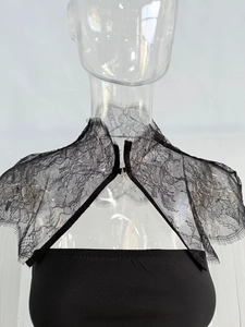 Détail du boléro en dentelle florale noire avec fermeture à crochet métallique