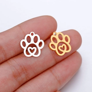 Detail of gold and silver hollow heart paw pendants held in hand for DIY jewelry making