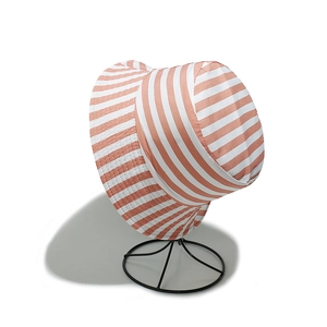 Détail du chapeau de soleil à rayures orange et blanches avec texture en maille et bord large