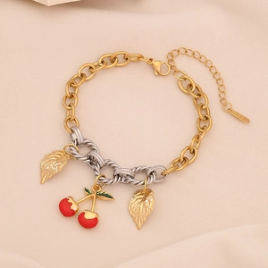 Stainless steel cherry pendant bracelet with gold and silver links on beige fabric