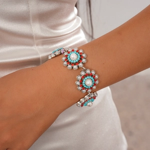 Close-up of retro floral bracelet with pearls, turquoise beads and red rhinestones