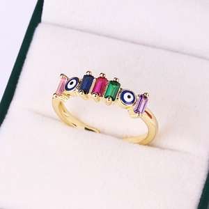 Macro shot of gold-plated evil eye ring with multi-color rectangular zircon stones