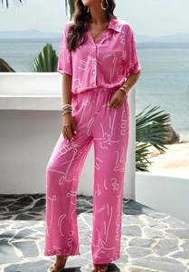 Detail of pink summer two-piece set featuring white face prints and Margo text patterns