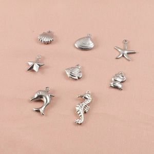 Close-up of assorted silver sea animal charms including starfish and dolphin for DIY jewelry