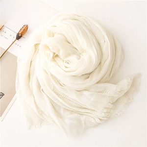 Close-up of cream white pleated scarf with soft fringe edges and linen texture
