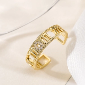 Gold plated open MOM letter ring with cubic zirconia micro-pave on silk fabric background