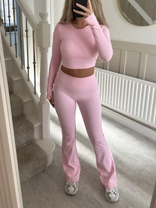 Pink Y2K yoga set with long sleeve crop top and flared pants shown in a mirror selfie