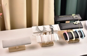 Detail view of wooden jewelry display stands with grey velvet and black leather T-bars