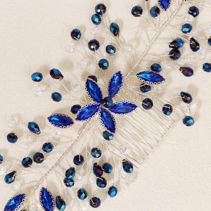 Close-up of vintage bridal hair comb with deep blue crystals and silver wire flower details