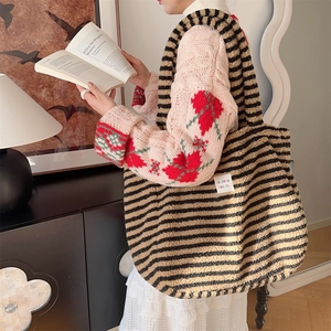 Close-up of plush black and brown striped tote bag with brand label and soft texture